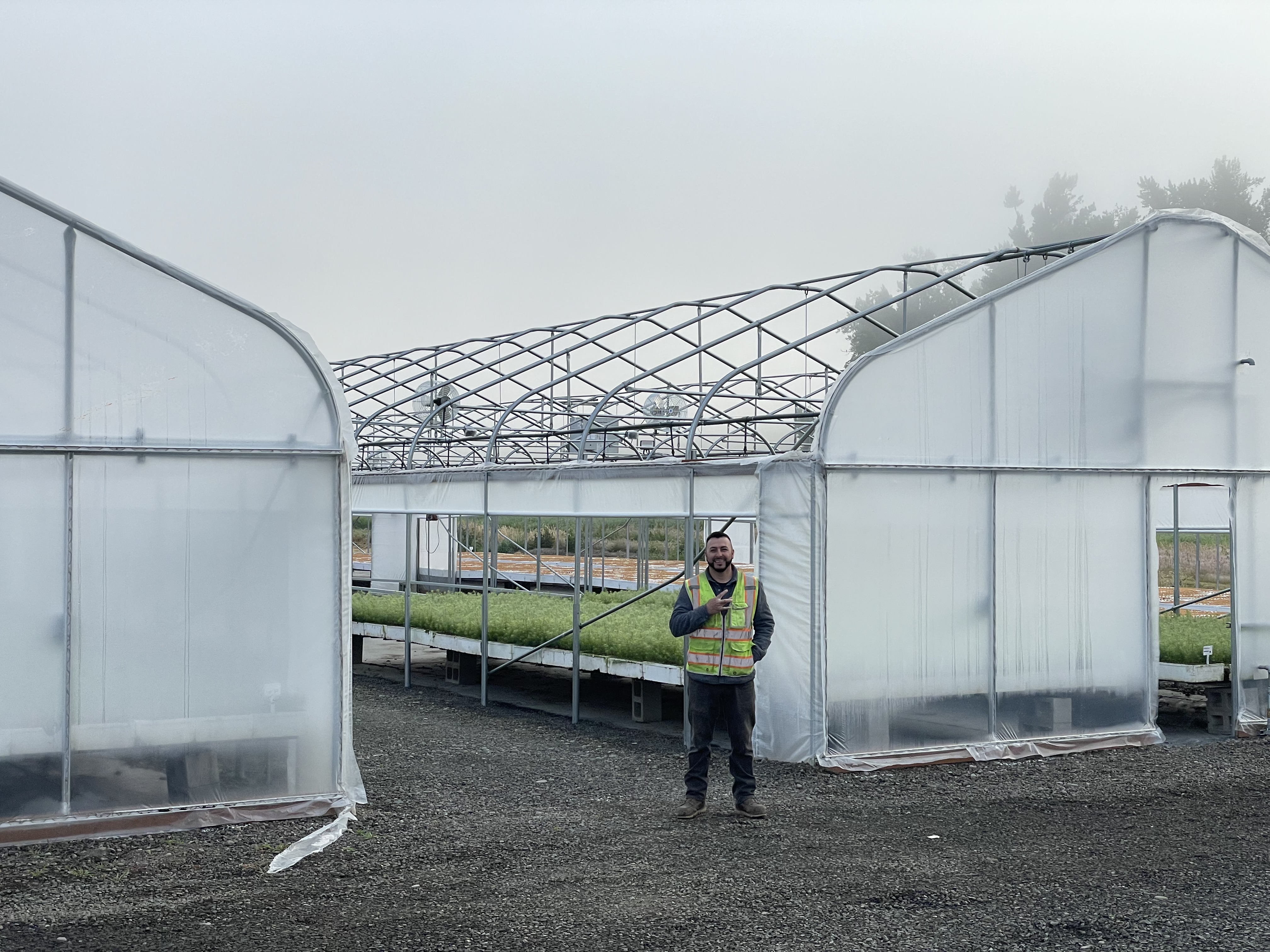 Image of Arturo Garcia, maintenance lead, in front of a newly completed greenhouse.